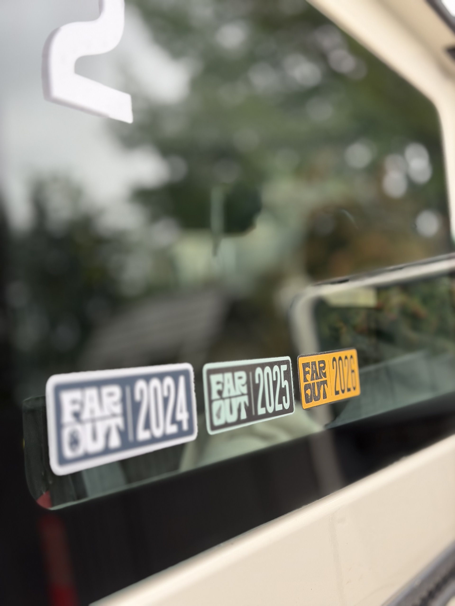 Far Out stickers for 2024, 2025, and 2026 on a van window