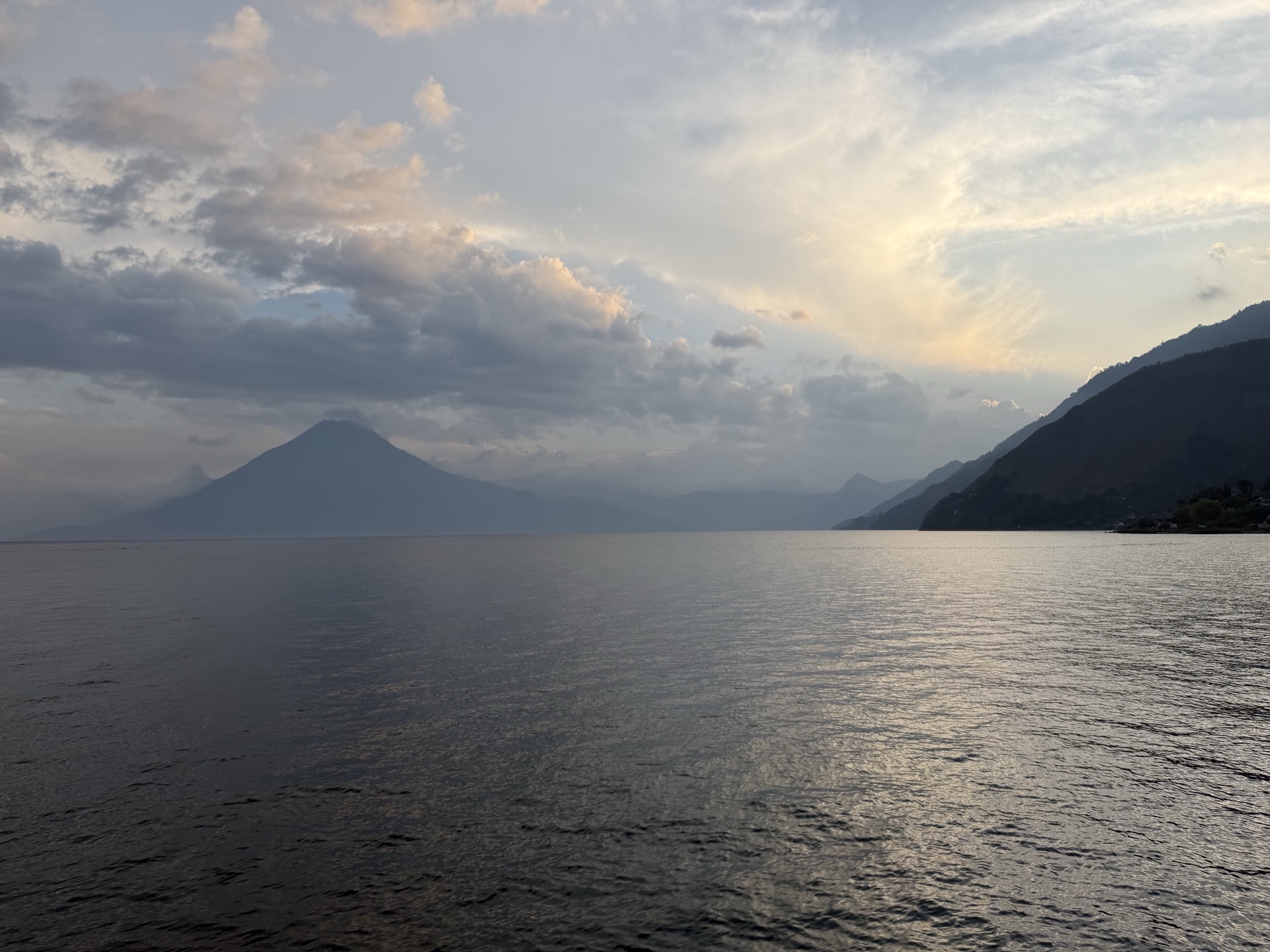 Lake Atitlán at dusk with a volcano on the horizon